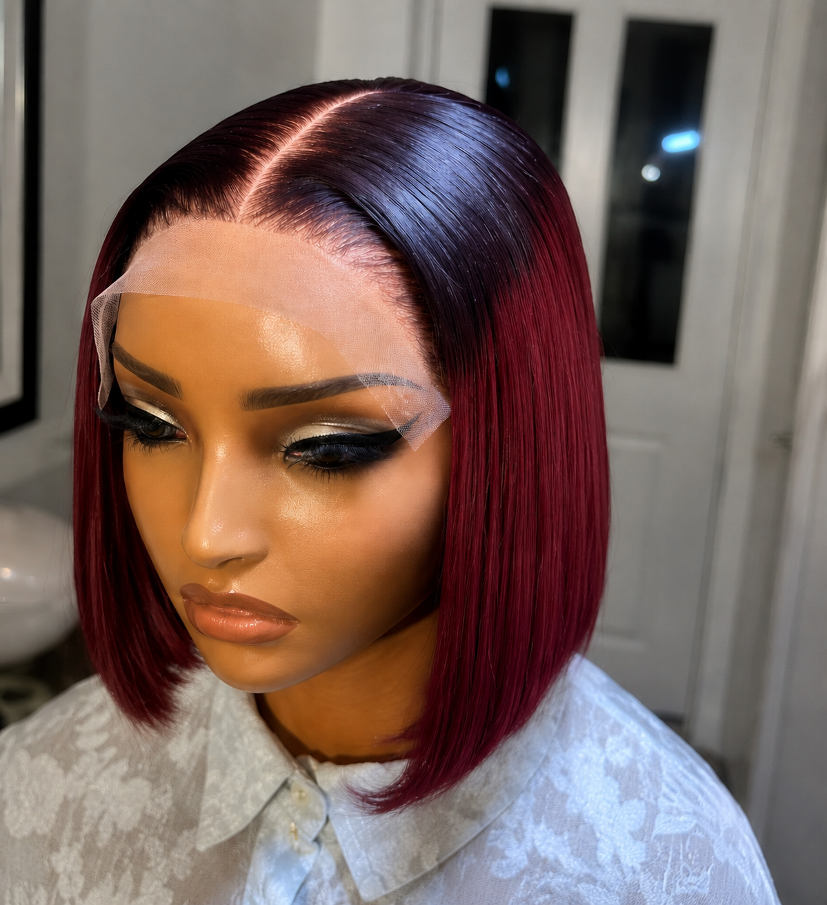 Mannequin head with burgundy bob wig in a neutral setting Image